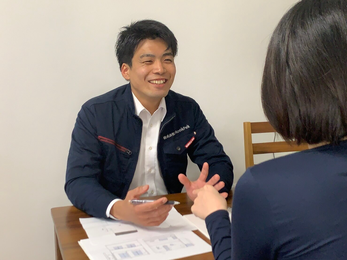 お客様へ住まいのメンテナンスについて説明する株式会社HookPek代表